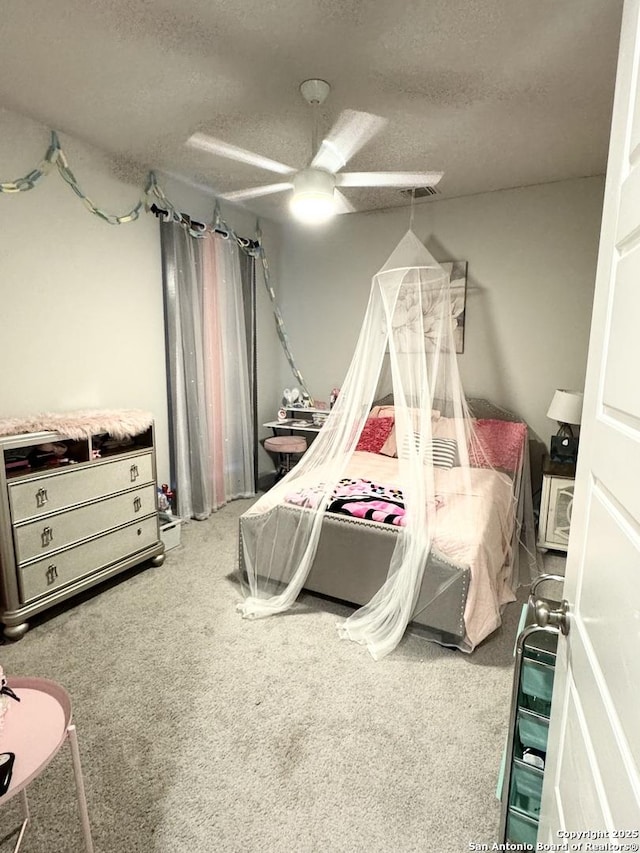 carpeted bedroom with a textured ceiling and a ceiling fan