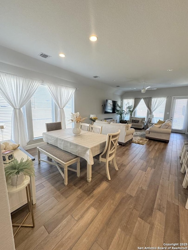 dining space featuring a textured ceiling, visible vents, hardwood / wood-style floors, and recessed lighting