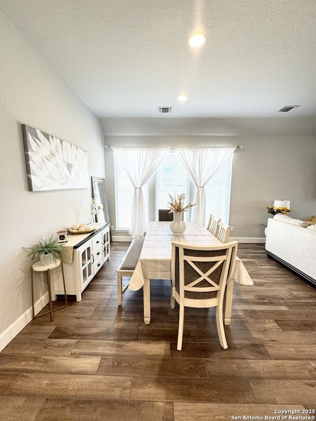 dining room with a textured ceiling, wood finished floors, and visible vents