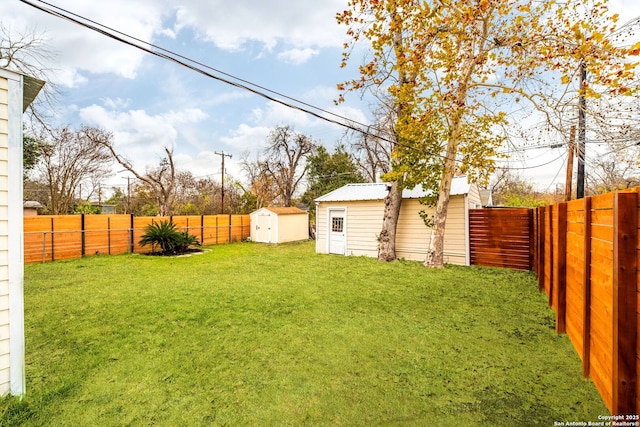 view of yard featuring an outbuilding, a fenced backyard, and a storage shed