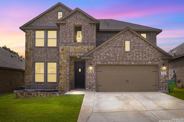 french country home featuring a garage, concrete driveway, brick siding, and a lawn