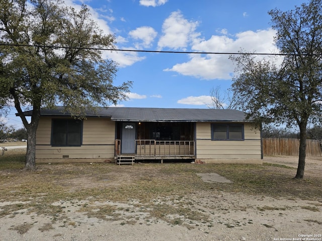 view of front of house with crawl space and fence