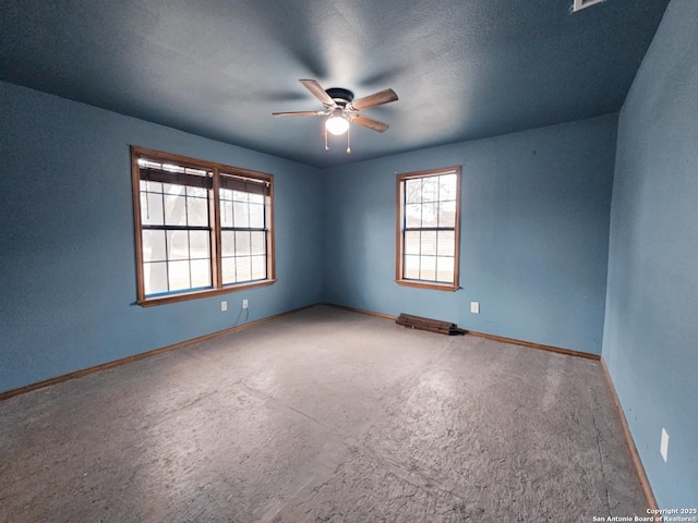 carpeted empty room featuring ceiling fan and baseboards