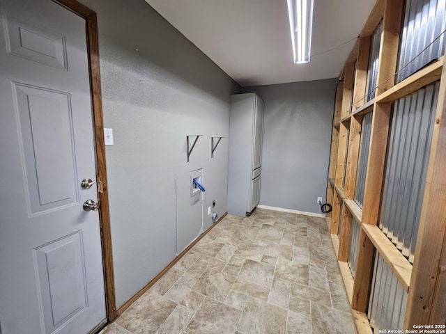 washroom with hookup for a washing machine, hookup for a gas dryer, laundry area, baseboards, and stone finish floor