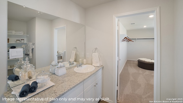 bathroom featuring a spacious closet and vanity