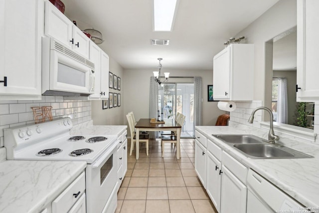 kitchen featuring white appliances, white cabinets, and a sink