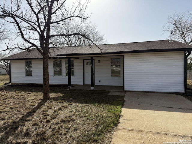 ranch-style house with a shingled roof and a front lawn