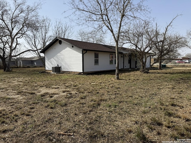 view of side of property with central AC and a lawn