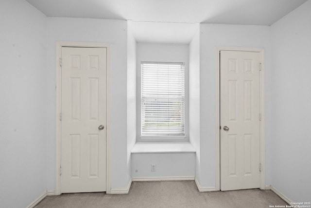 interior space with light carpet and baseboards