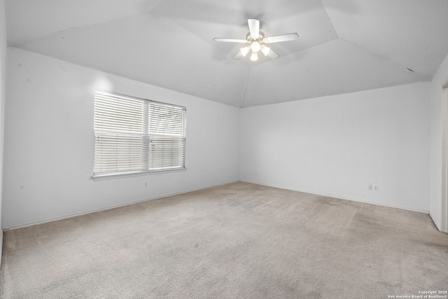 carpeted spare room with vaulted ceiling and ceiling fan