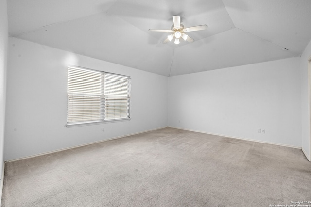 carpeted empty room with baseboards, vaulted ceiling, and a ceiling fan