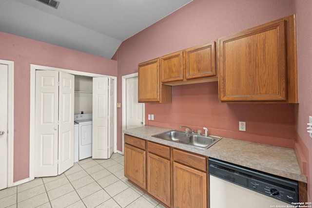 kitchen with light tile patterned floors, lofted ceiling, white dishwasher, washer and dryer, and a sink