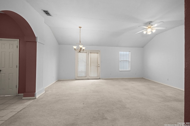 carpeted empty room featuring baseboards, visible vents, arched walkways, lofted ceiling, and ceiling fan with notable chandelier