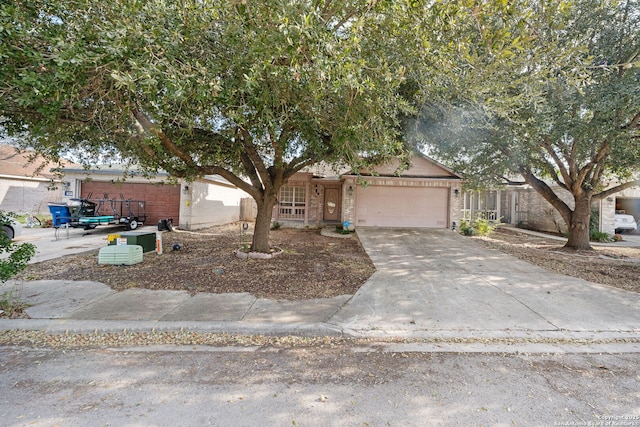 single story home with a garage, concrete driveway, and brick siding