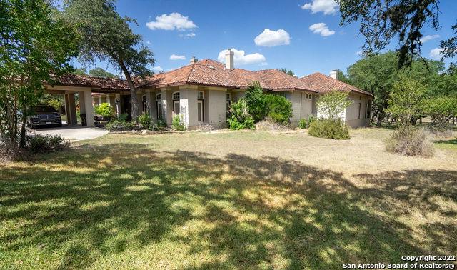 mediterranean / spanish-style home featuring a garage, a front lawn, and a carport