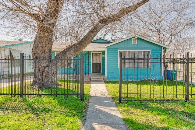 bungalow-style home featuring a fenced front yard, a front yard, and a gate