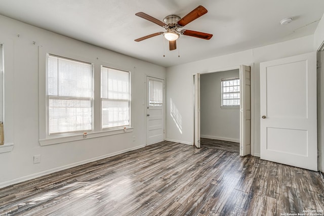 empty room featuring wood finished floors, a ceiling fan, and baseboards