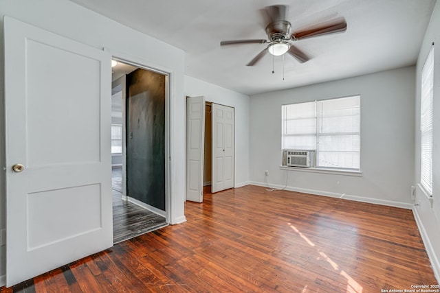 unfurnished bedroom with cooling unit, baseboards, ceiling fan, and hardwood / wood-style floors