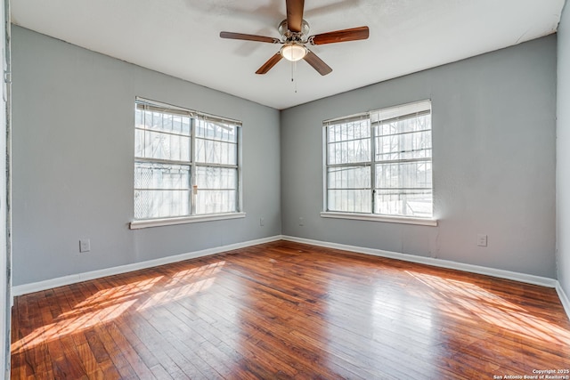 unfurnished room featuring a ceiling fan, hardwood / wood-style flooring, and baseboards