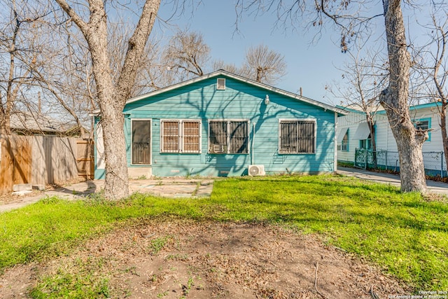 bungalow-style home featuring fence and a front lawn