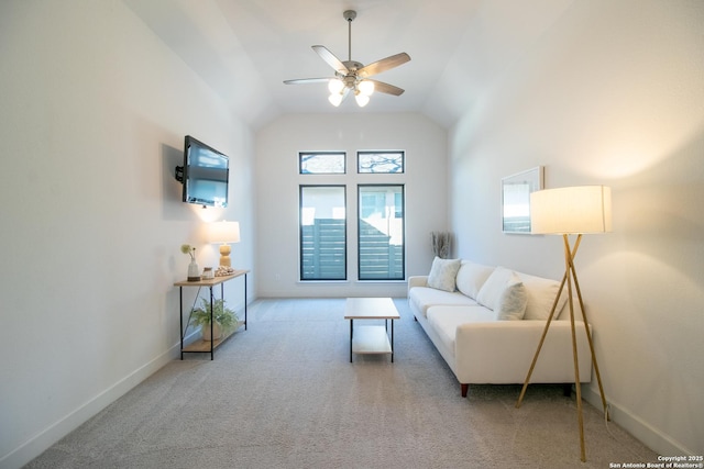 carpeted living area with ceiling fan, baseboards, and vaulted ceiling