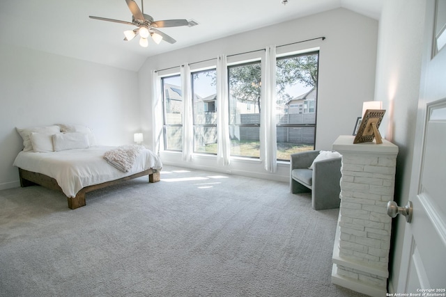 carpeted bedroom featuring baseboards, vaulted ceiling, and a ceiling fan