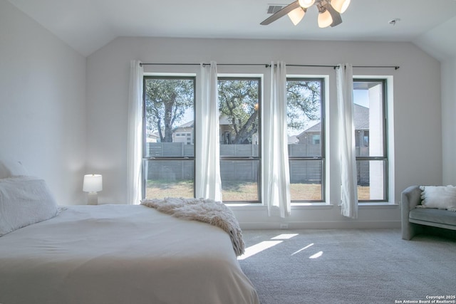 bedroom with vaulted ceiling, multiple windows, and carpet