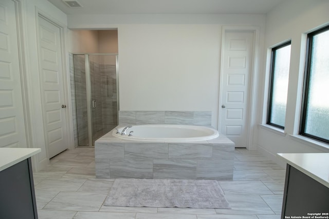 bathroom with a bath, visible vents, a stall shower, and vanity