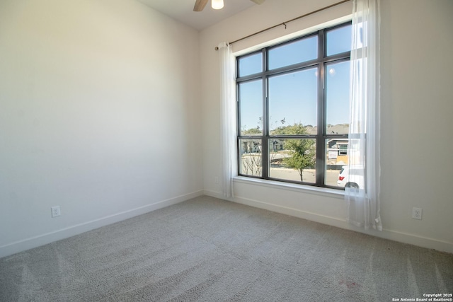 spare room with light carpet, ceiling fan, and baseboards