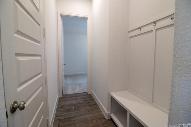 mudroom featuring dark wood finished floors and baseboards