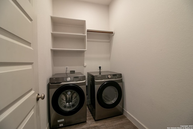 washroom with laundry area, washer and clothes dryer, wood finished floors, and baseboards