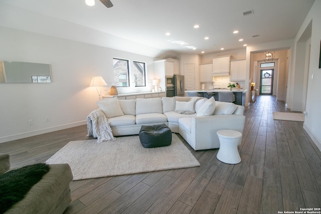 living area featuring recessed lighting, visible vents, dark wood finished floors, and baseboards