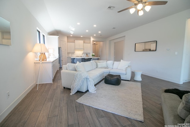 living room with recessed lighting, wood finished floors, visible vents, and baseboards