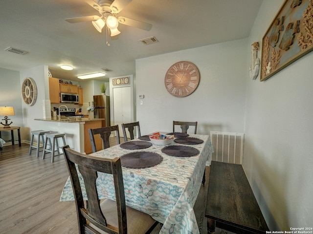 dining area featuring ceiling fan, light wood-type flooring, and visible vents