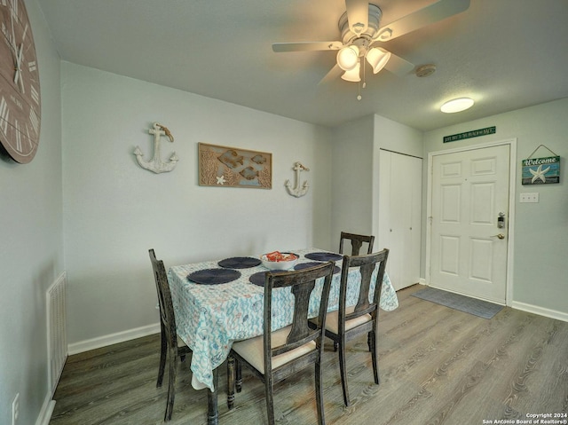 dining space with wood finished floors, visible vents, and baseboards