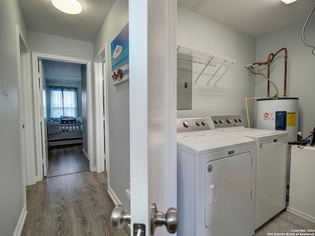 laundry area featuring electric water heater, wood finished floors, washer and dryer, laundry area, and electric panel