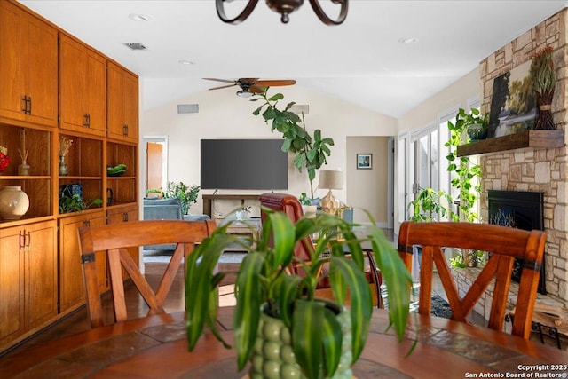 interior space featuring lofted ceiling, a fireplace, visible vents, and a ceiling fan