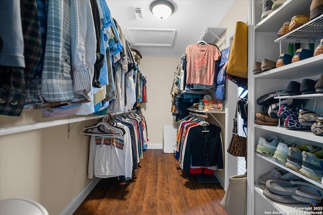 walk in closet featuring attic access and wood finished floors