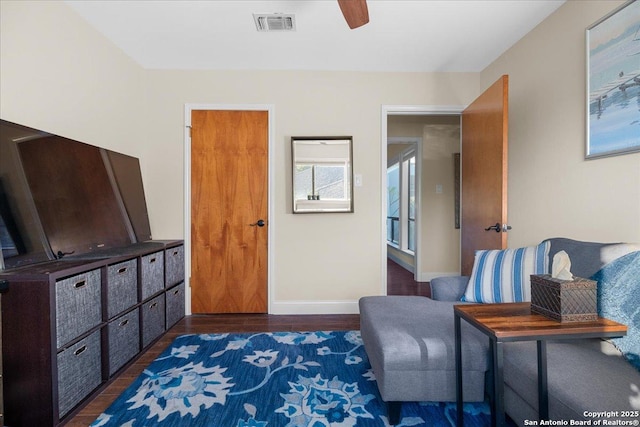 living area with wood finished floors, visible vents, and baseboards