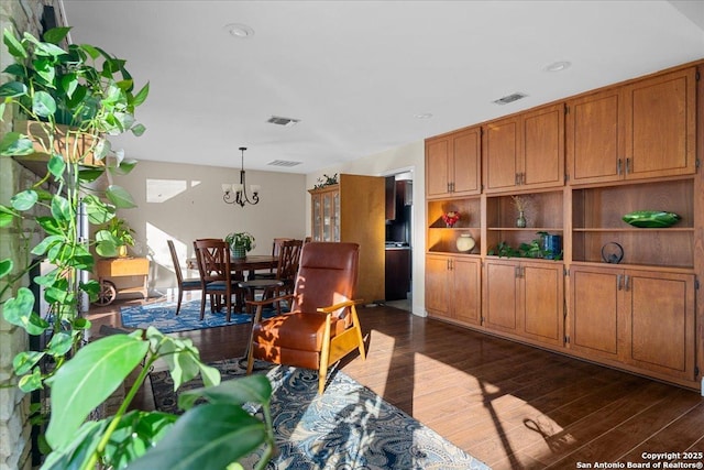 living area with dark wood-style flooring and visible vents