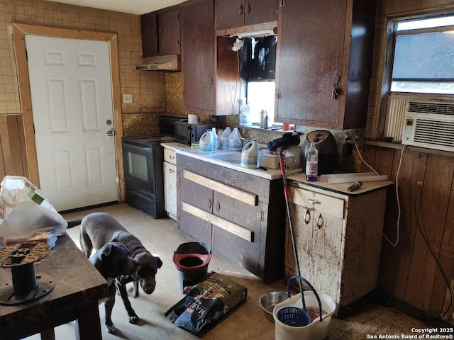 kitchen featuring ventilation hood, black range with electric cooktop, cooling unit, and a wealth of natural light