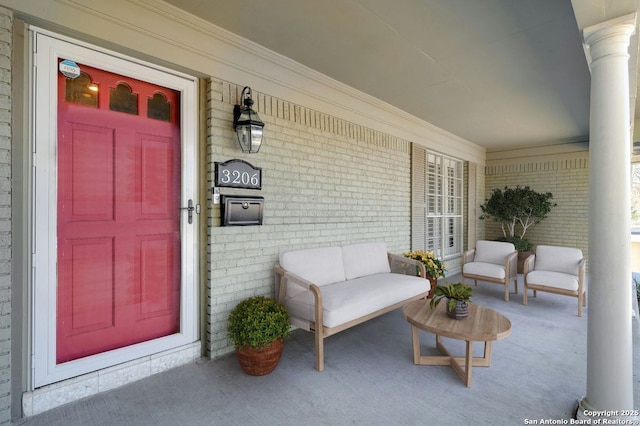 entrance to property with covered porch and brick siding