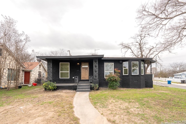 view of front facade with brick siding and a front yard