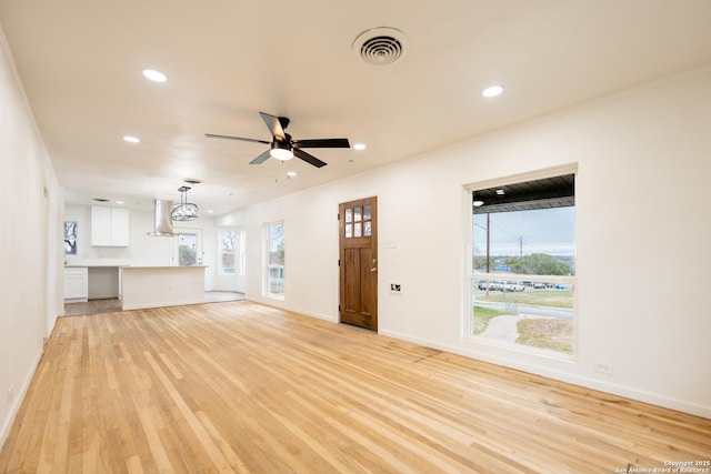 unfurnished living room with baseboards, visible vents, a ceiling fan, light wood-style floors, and recessed lighting