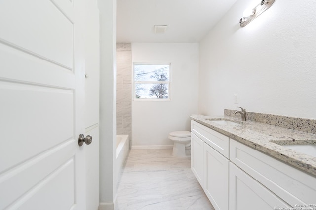 bathroom featuring marble finish floor, double vanity, toilet, a sink, and walk in shower