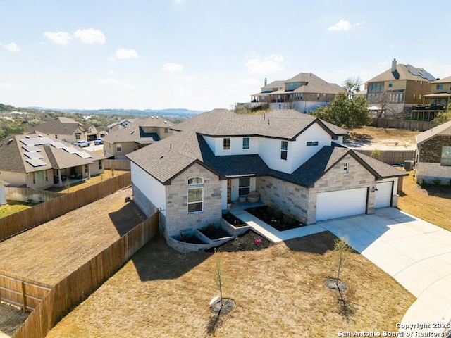 view of front of property with concrete driveway, a fenced backyard, and a residential view