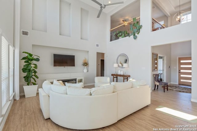 living area with visible vents, baseboards, and wood finished floors