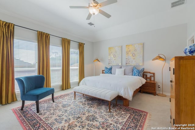 bedroom with ceiling fan, visible vents, baseboards, and light colored carpet