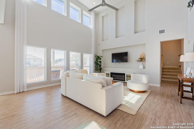 living area featuring a healthy amount of sunlight, visible vents, and light wood-style flooring