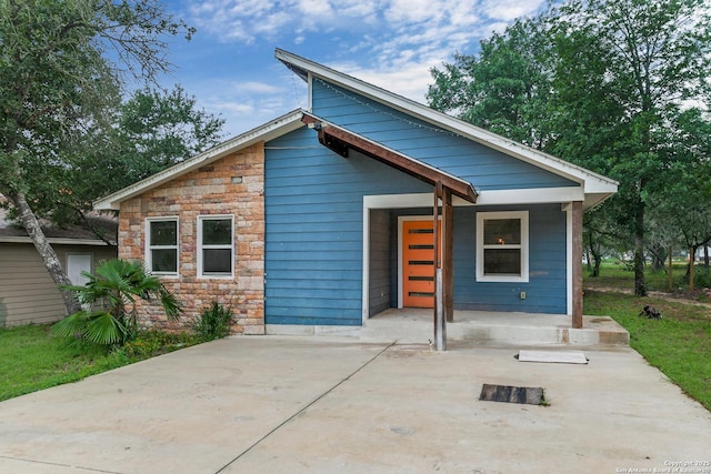 view of front facade with stone siding and covered porch